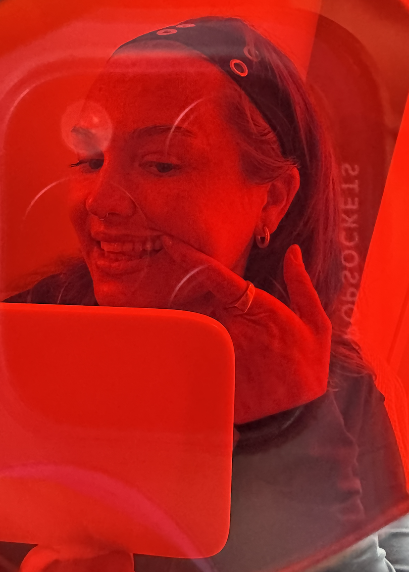 Client smiling with a tooth gem under red studio light